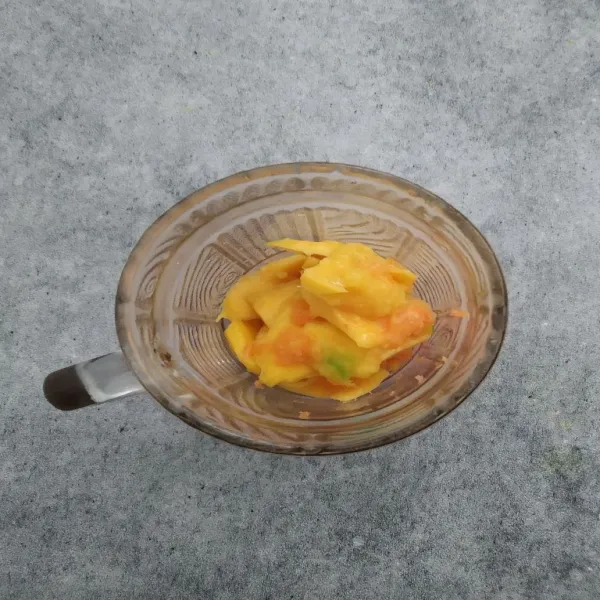 Tuang wortel, apel dan mangga ke dalam gelas.