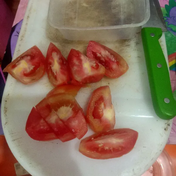 Cuci bersih tomat lalu belah menjadi empat.