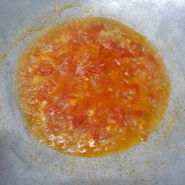 Masukkan irisan tomat, tumis sambil ditekan-tekan tomatnya agar hancur. Tuang air secukupnya. Masak sampai air mendidih.