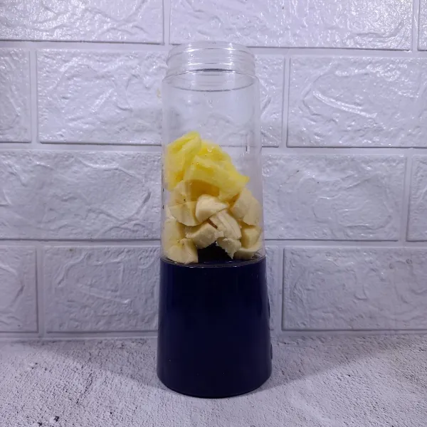 Masukkan nanas dan pisang ke dalam blender.