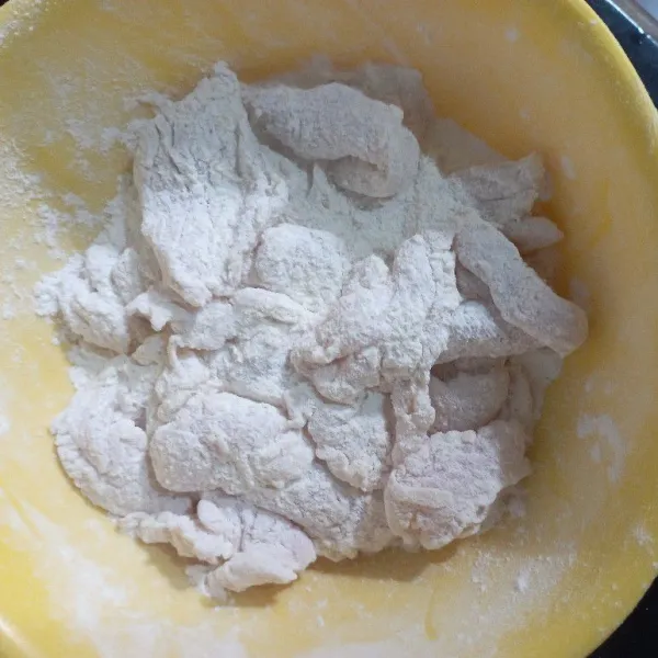 Kibas-kibas ayam agar tepung yang tidak menempel lepas.