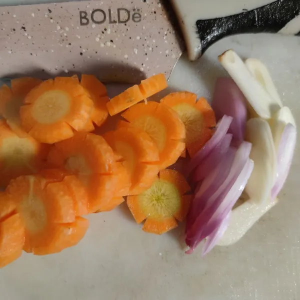 Potong wortel dan iris bawang merah, bawang putih.