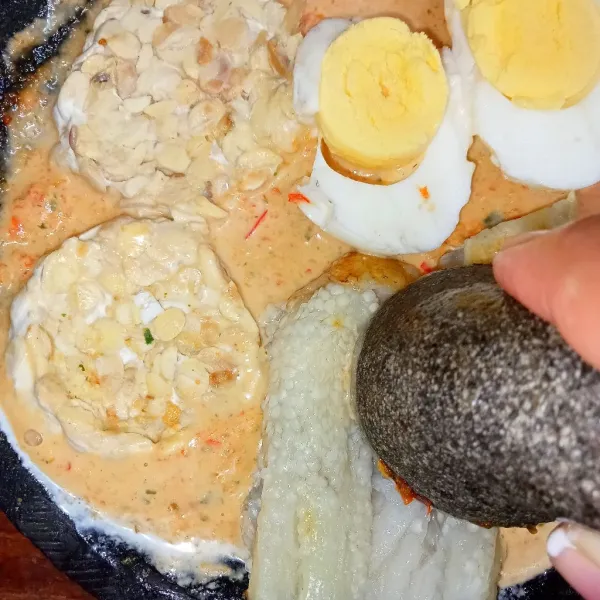 Masukkan tempe, telur, dan terong. Penyet sedikit tempe dan terong.