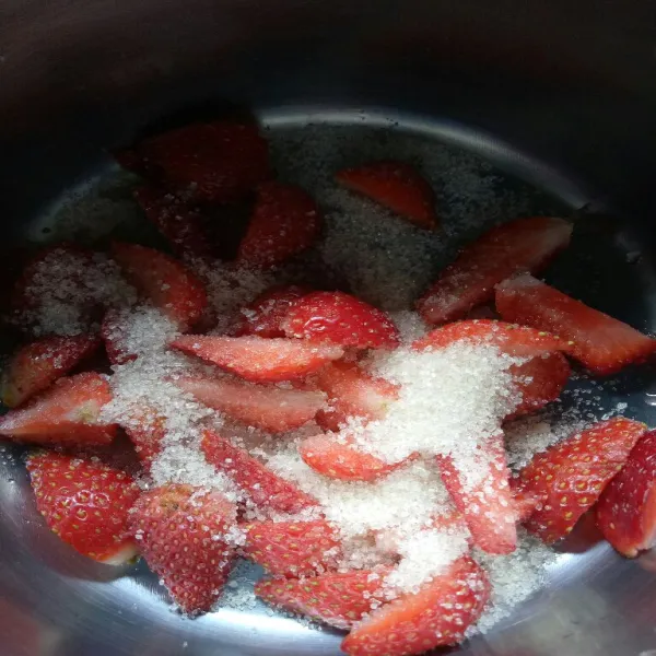 Potong dan cuci bersih strawberry. Masukkan gula dan strawberry ke dalam wajan.