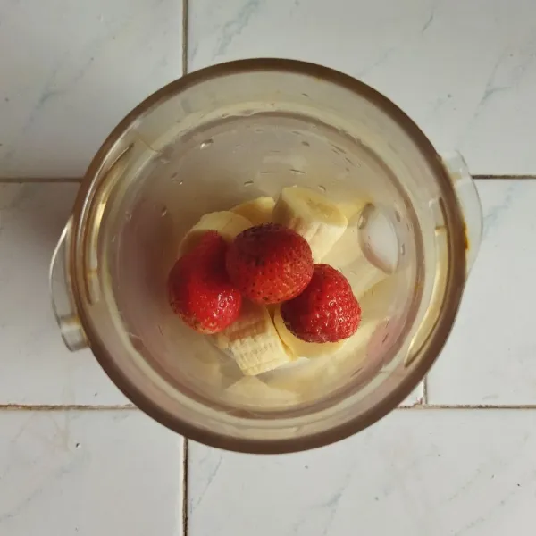 Masukan pisang dan strawberry yang sudah dibekukan ke dalam blender.