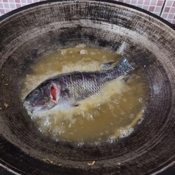 Marinasi ikan dengan garam dan bumbu ikan, goreng selama 5 menit kemudian goreng hingga matang, angkat dan tiriskan.