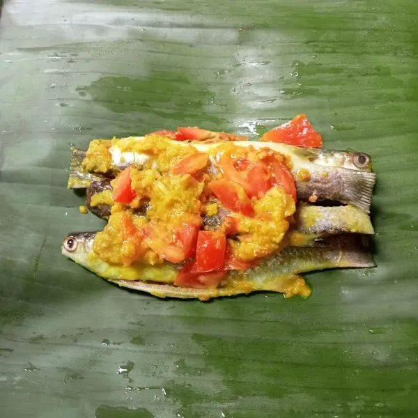 Letakkan ikan diatas daun pisang, bungkus ikan dan semat ujungnya dengan lidi.