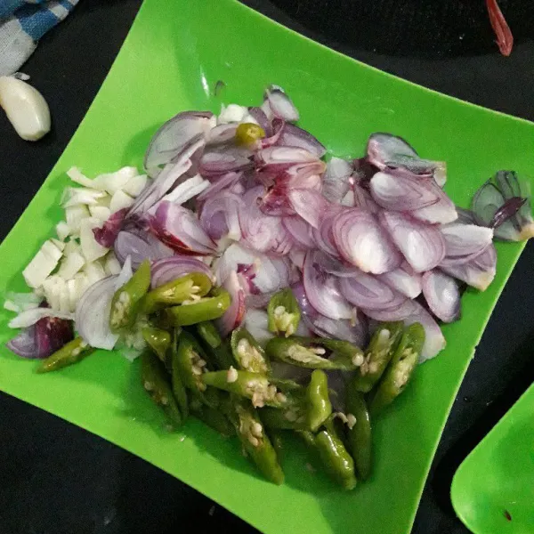 Iris tipis bawang merah dan cincang bawang putih. Untuk cabe rawit diiris tipis.