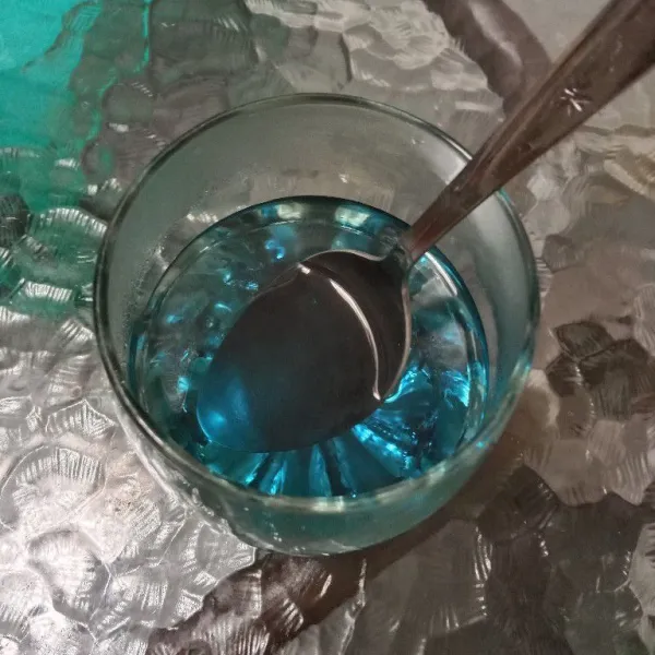 Tuang secukupnya air rebusan telang dalam gelas.