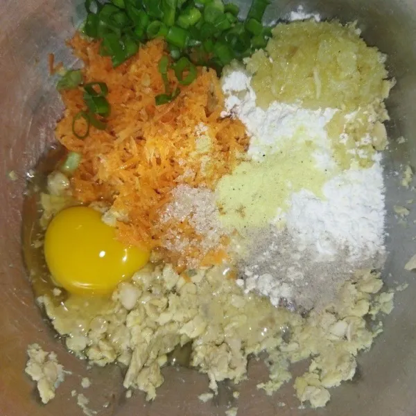 Lalu tambahkan bawang putih halus, daun bawang, wortel, tepung terigu, kaldu bubuk, garam, lada bubuk, gula pasir, dan telur lalu aduk rata.