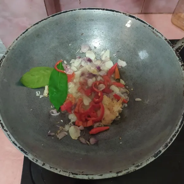 Tumis irisan bawang merah dan bawang putih kemudian masukkan lengkuas, salam dan cabe.