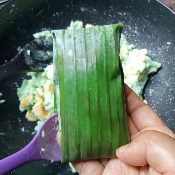 Ambil dua sendok makan adonan dan bungkus dengan daun pisang, lakukan hal yang sama sampai adonan habis.