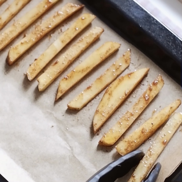 Setelah semua tercampur rata. Siapkan tray oven dengan baking paper, atur kentang yang sudah diiris agar tidak saling menempel. Panggang di oven dengan suhu 180°C selama kurang lebih 25 menit