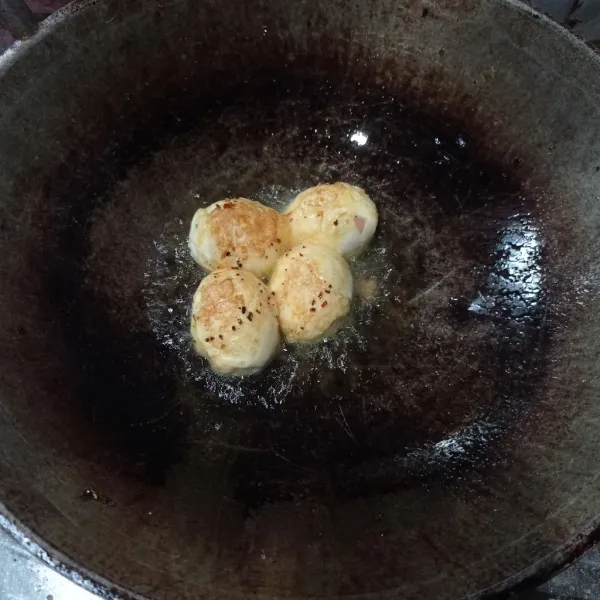 Rebus telur sampai matang, kupas lalu goreng sampai berkulit, tiriskan.