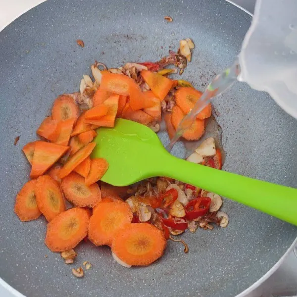 Masukkan irisan wortel dan tambahkan air. Rebus hingga wortel empuk.