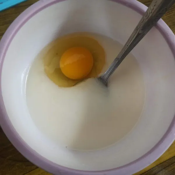 Campur air, susu kental manis, garam, gula, dan telur kocok menggunakan garpu hingga tercampur rata.