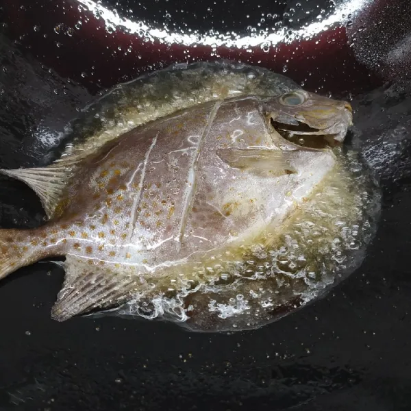 Goreng ikan sampai matang di kedua sisi, lalu angkat dan tiriskan. Letakkan di atas piring saji.