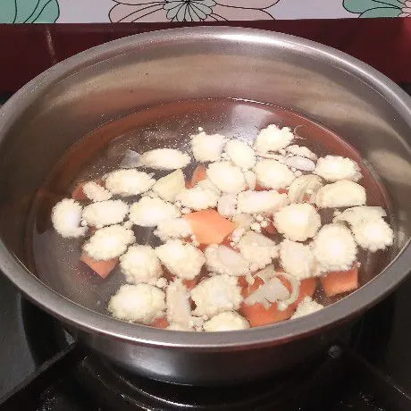 Rebus air, lalu masukkan wortel dan jagung muda. Masak sampai empuk.