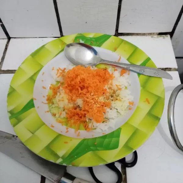 Masukkan nasi dan wortel parut dalam wadah. Aduk rata.