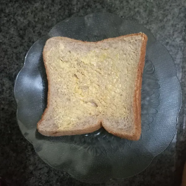 Tumpuk roti, lalu olesi kedua sisi roti dengan margarin.