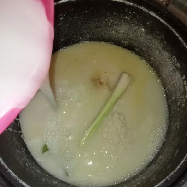 Masukkan santan dan air, aduk rata. Untuk takaran air disesuaikan dengan kondisi beras masing-masing. Tutup rice cooker dan tekan tombol cook.
