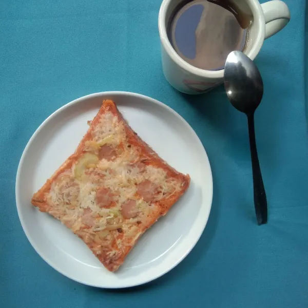 Pindahkan pizza roti tawar ke piring saji dan siap dinikmati bersama teh hangat.