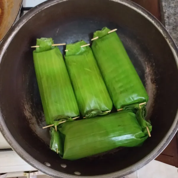 Panggang nasi dalam daun di atas teflon hingga daun pisang kecokelatan.