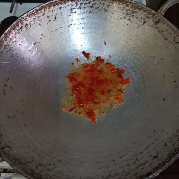 Haluskan bawang putih, cabe rawit dan cabe merah keriting, tumis bumbu halus hingga harum.