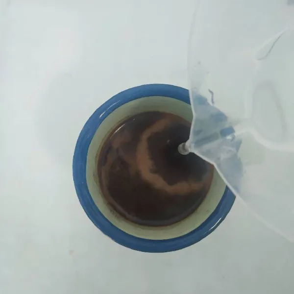 Seduh kopi bubuk dengan 100ml air panas, aduk rata.