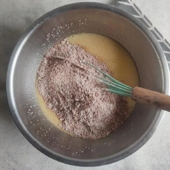 Masukkan tepung, coklat bubuk, baking powder, dan baking soda, aduk kembali hingga tercampur rata.