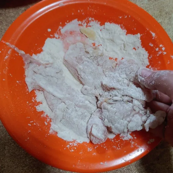 Balur daging ayam dengan tepung kering sampai merata.