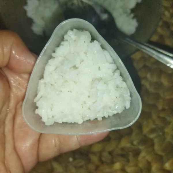 Siapkan cetakan onigiri lalu tata nasi secukupnya.