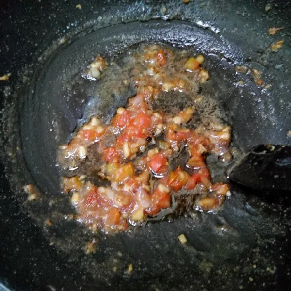 Cincang halus bawang putih dan bawang merah. Untuk tomat buang bijinya, lalu iris halus. Kemudian di tumis hingga harum menggunakan sedikit minyak.