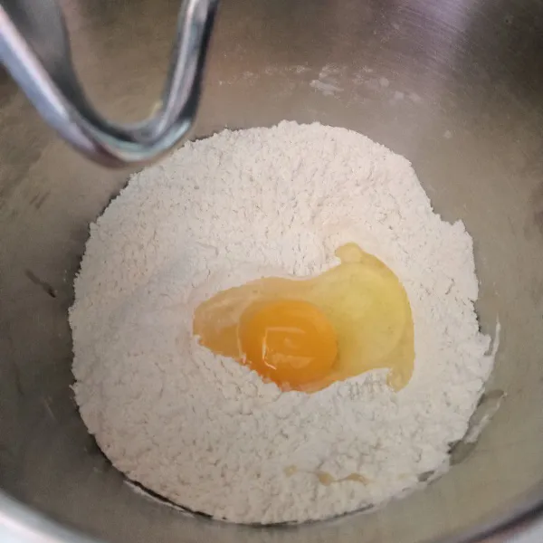 Masukkan tepung, telur, dan susu 60 ml dan juga bahan biang. Mixer sampai setengah kalis. Masukkan butter dan garam, mixer sampai kalis elastis.