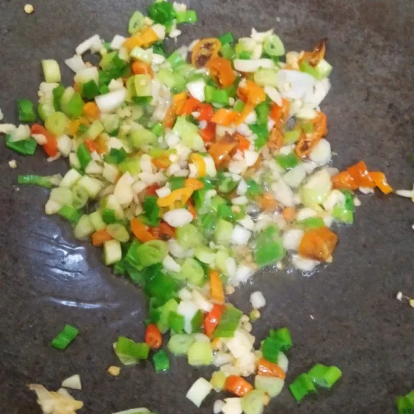 Panaskan minyak, tumis bawang putih, cabe dan daun bawang hingga setengah kering.