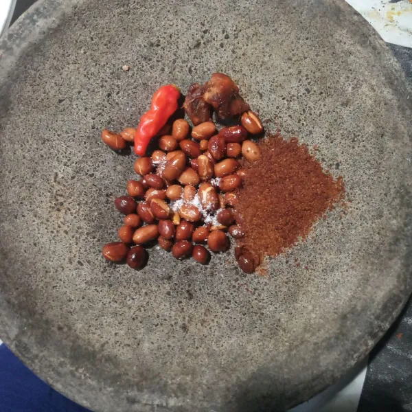 Taruh di cobek kacang tanah goreng, garam, gula palem, cabai dan asam jawa.