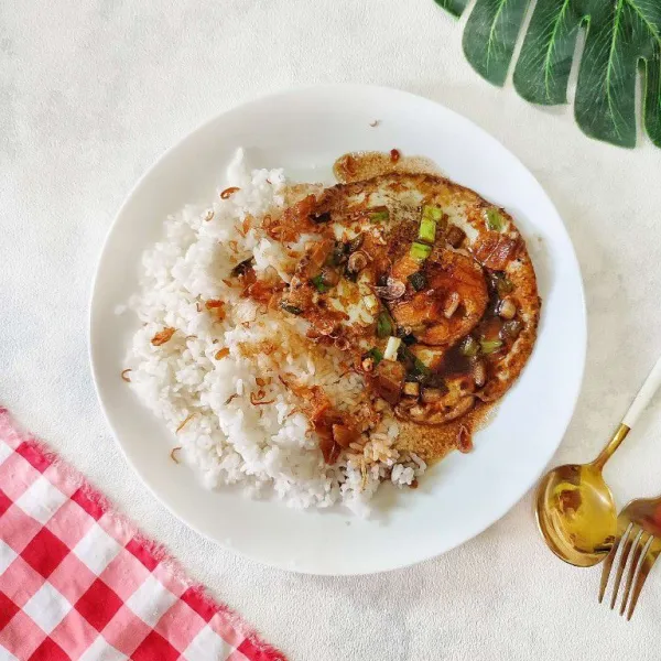 Tuang nasi putih ke atas piring saji, kemudian tata telur kecap di atasnya. Lalu taburi dengan bawang goreng. Sajikan selagi hangat.