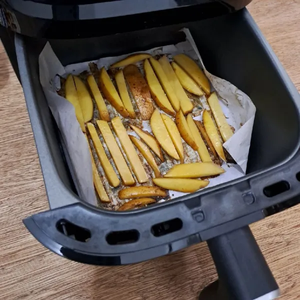 Masukkan ke dalam tray air fryer yang dialasi baking paper. Tata kentang dengan jarak agar tidak menempel.