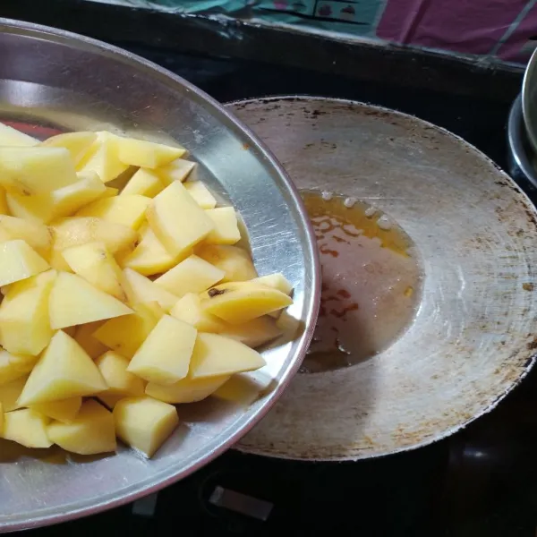 Iris kentang kecil-kecil, kemudian goreng hingga kering dan matang.