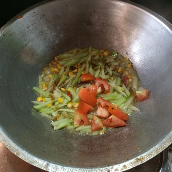 Kemudian masukkan labu siam, tomat, saus tiram, lada bubuk, kaldu jamur dan garam secukupnya. Aduk rata.