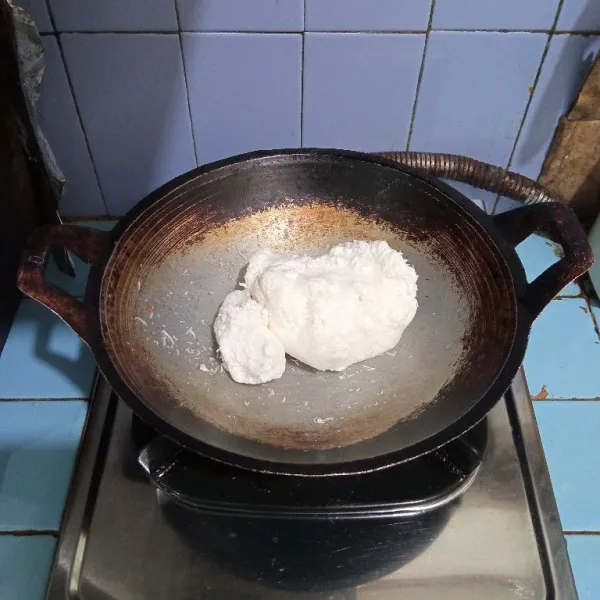 Siapkan kelapa parut di wajan.