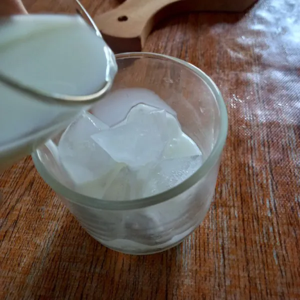 Tuang susu cair ke dalam gelas saji
