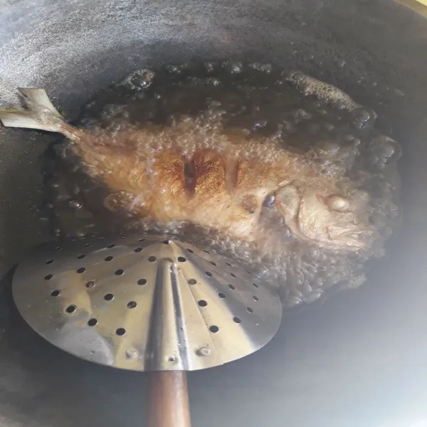 Goreng ikan dengan minyak panas.