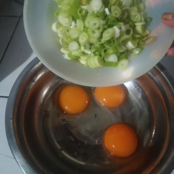 Siapkan telur, kocok bersama irisan daun bawang