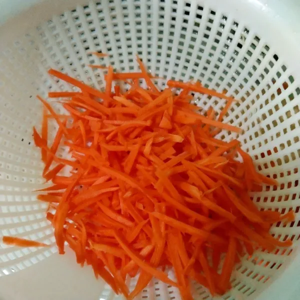 Kupas wortel lalu parut, cuci dan tiriskan.