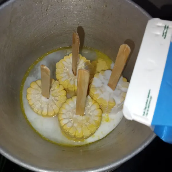 Masukkan jagung kedalam panci, lalu tuang susu cair full cream dan kental manis.