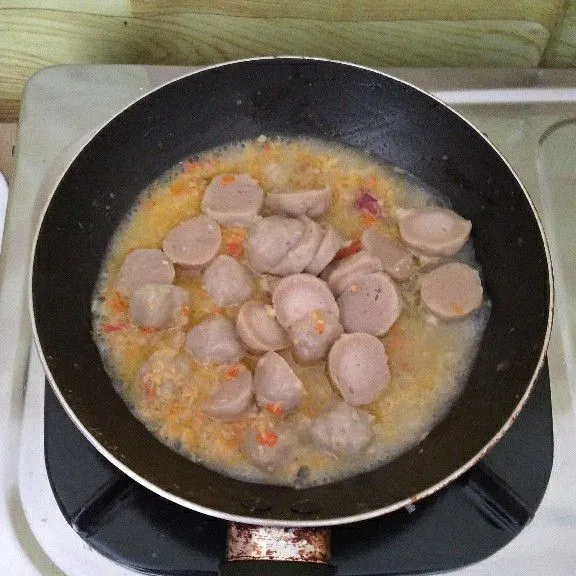 Tuang 50 ml air , masukkan pentol , saos tomat , kecap manis , kaldu jamur , garam , lad bubuk lalu aduk serta koreksi rasa sesuai selera.