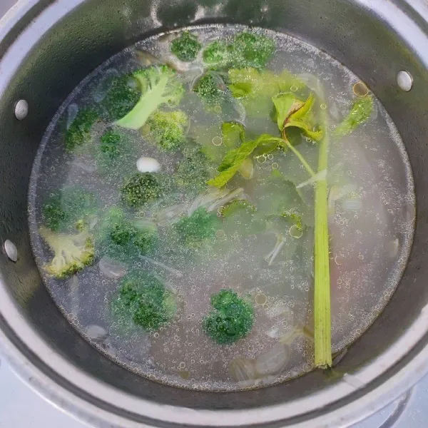 Masukkan brokoli, daun seledri, irisan daun bawang dan sisa air. Rebus hingga brokoli matang.