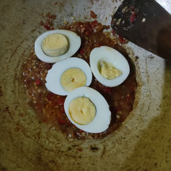 Masukkan telur, kemudian siram dengan bumbu (jangan diaduk, karena telur rebus potong rawan hancur), lalu matikan api.