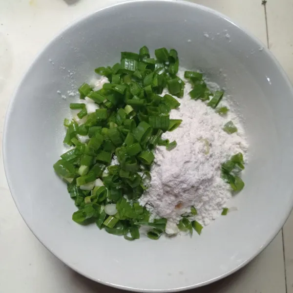 Masukan tepung beras, tepung terigu, bumbu halus, garam, kaldu bubuk dan daun bawang ke dalam mangkok